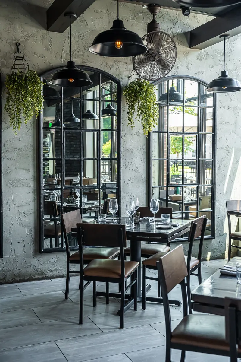 Warmly lit Culaccino dining room with curved arches and set tables