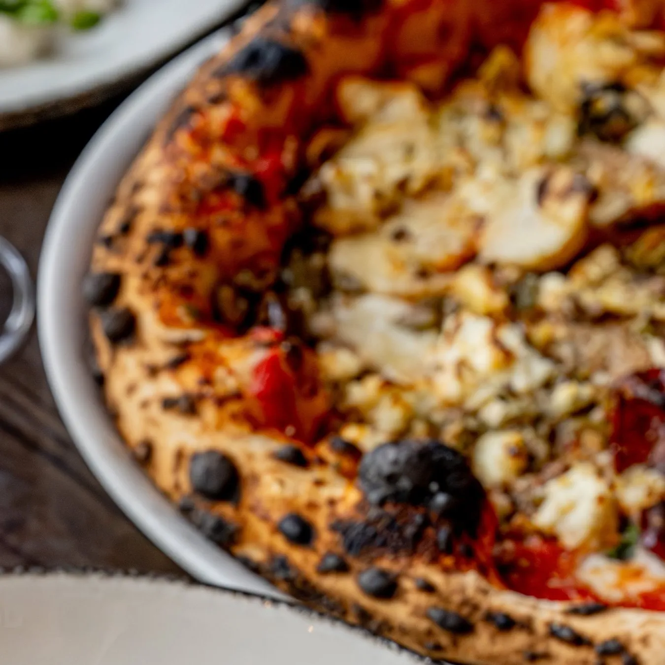 Wood-fired pizza with a charred, airy crust
